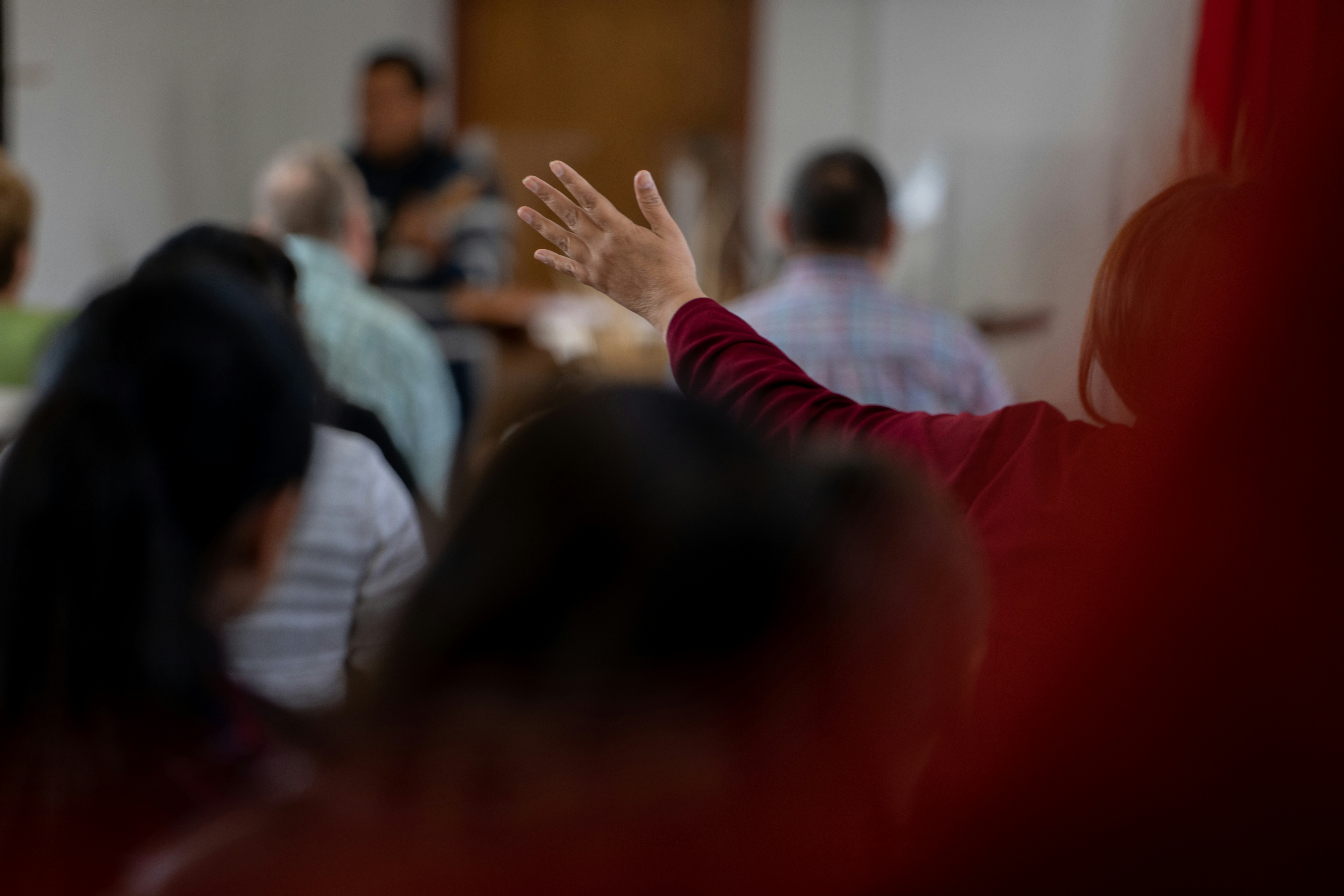 Person raising their hand to ask a question